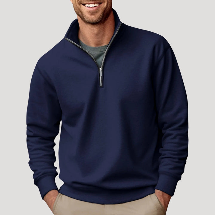 Navy blue men's quarter-zip sweatshirt with a funnel neck collar and relaxed fit, styled over a grey t-shirt.