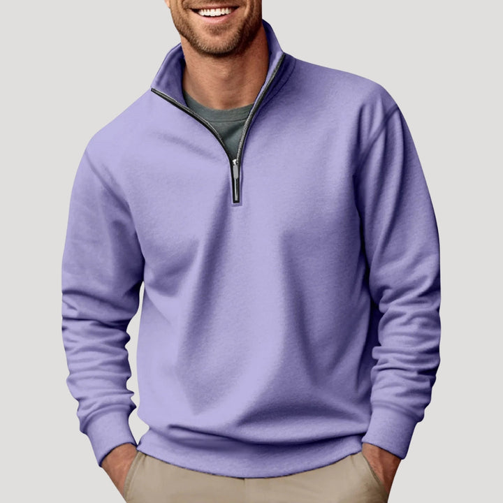 Man wearing a soft, lavender quarter-zip sweatshirt with a funnel neck and relaxed fit over a grey t-shirt.