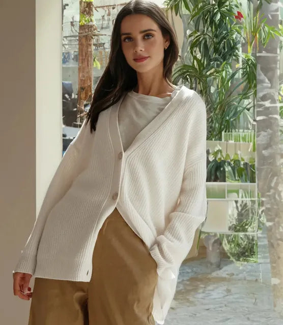 Woman wearing an oversized, white ribbed V-neck cardigan with a soft brushed texture and button-front closure.