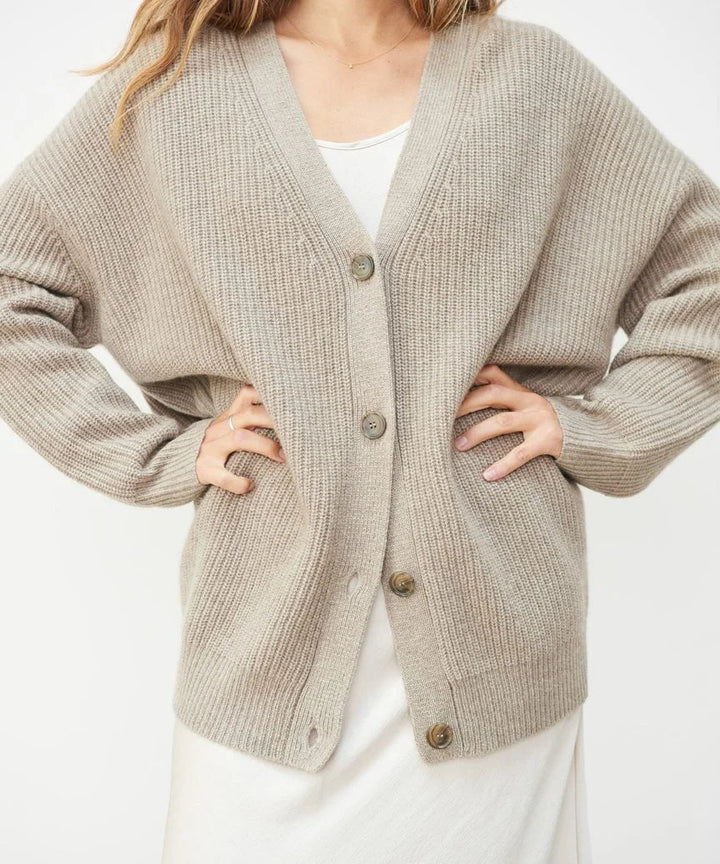 Oversized beige ribbed V-neck cardigan with a soft brushed texture, dropped shoulders, and a button-front closure.