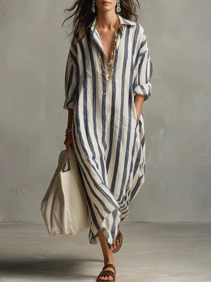 Woman wearing a relaxed, vertical-striped linen maxi shirt dress with an open collar and long sleeves.