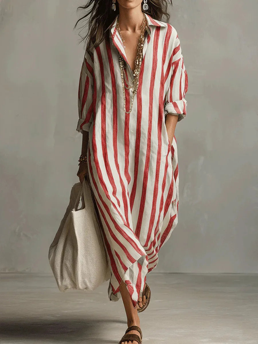 Woman wearing a loose, red and white striped linen maxi shirt dress with an open collar and long sleeves.