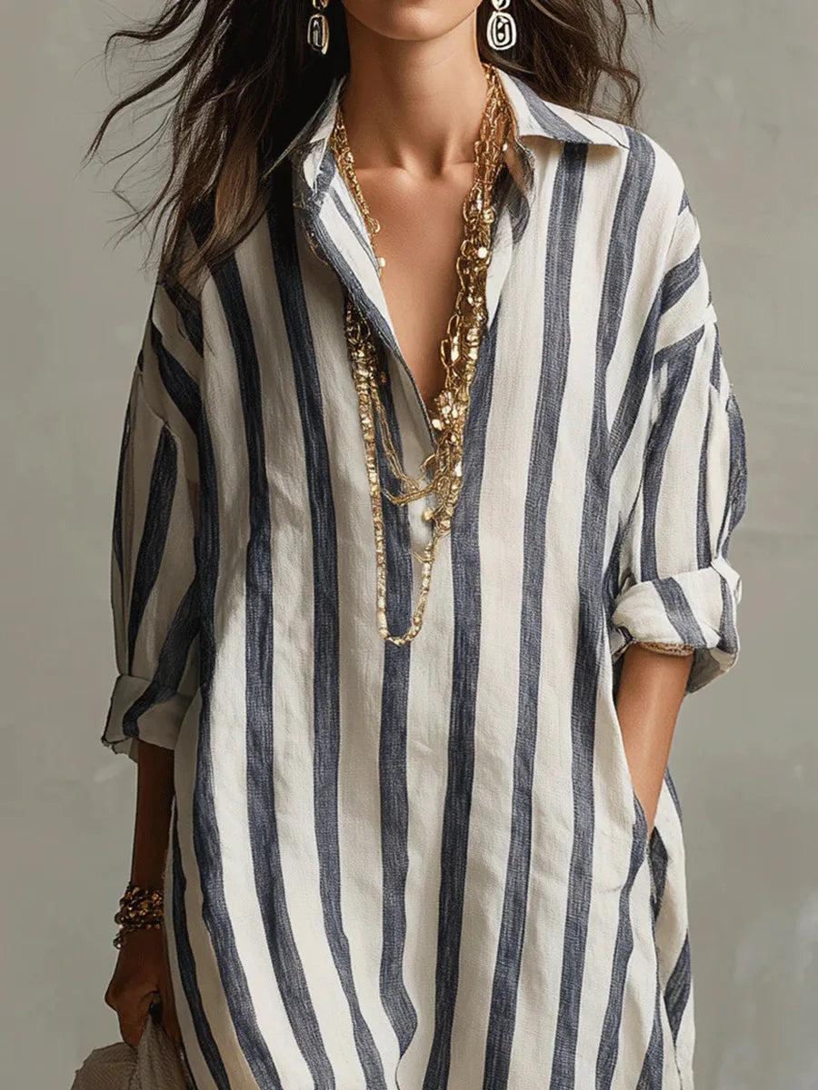 Woman wearing a relaxed-fit, navy and white vertical striped linen maxi shirt dress with an open collar.