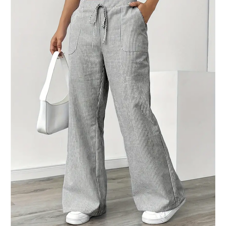 Women's grey and white striped linen wide-leg trousers with a drawstring waist and side pockets.