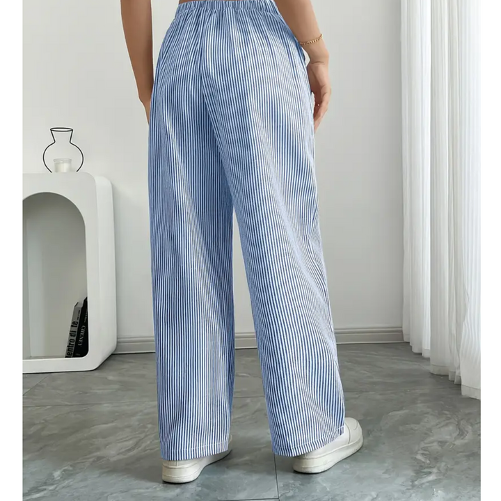 Women's wide-leg linen trousers featuring blue and white vertical stripes with a comfortable drawstring waist.