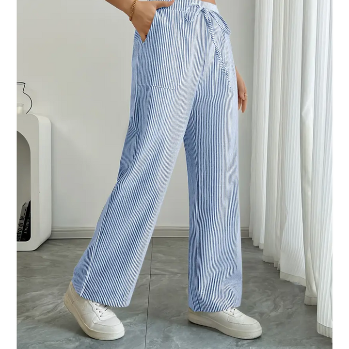 Amelia wide-leg linen trousers in blue and white vertical stripes with a drawstring waist and side pockets.