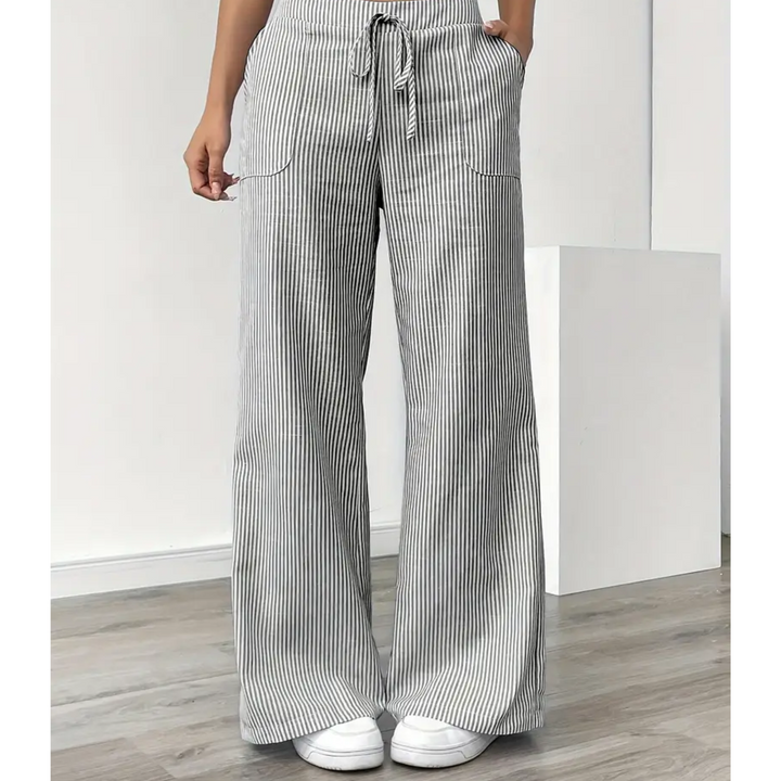 Amelia wide-leg linen trousers in grey and white vertical stripes with a drawstring waist and side pockets.