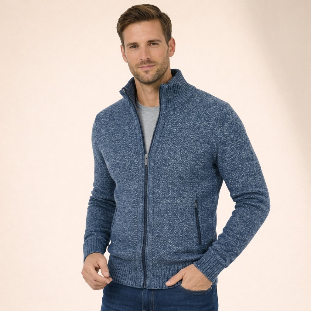 Man wearing a blue marled merino wool full-zip jumper with a ribbed funnel collar and side zip pockets.