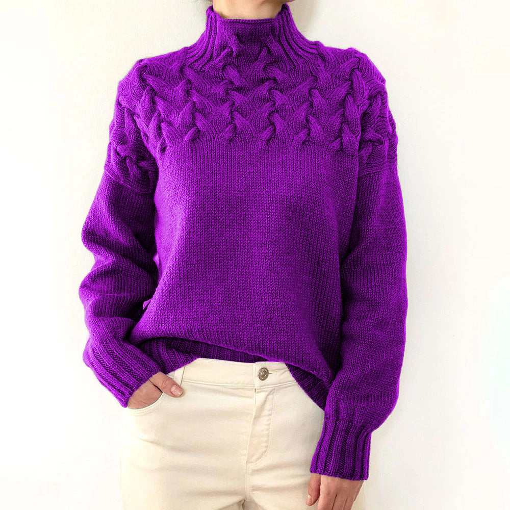 Vibrant purple cable knit turtleneck jumper with a braided yoke, relaxed fit, and ribbed cuffs worn with cream trousers.