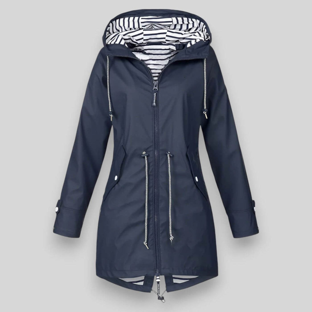 Navy blue waterproof longline raincoat with an adjustable hood, drawcord waist, and nautical striped inner lining.