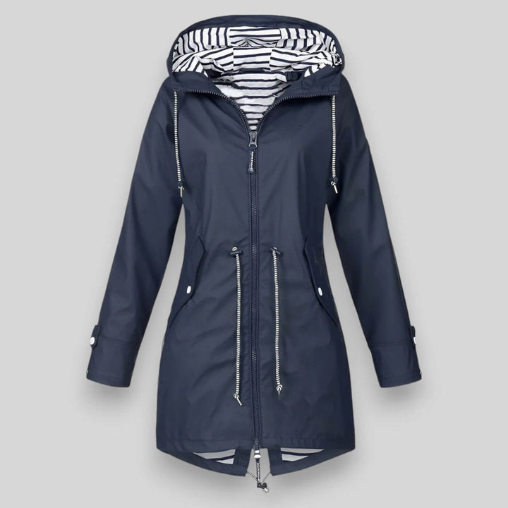 Navy blue waterproof longline raincoat with an adjustable hood, drawcord waist, and nautical striped inner lining.