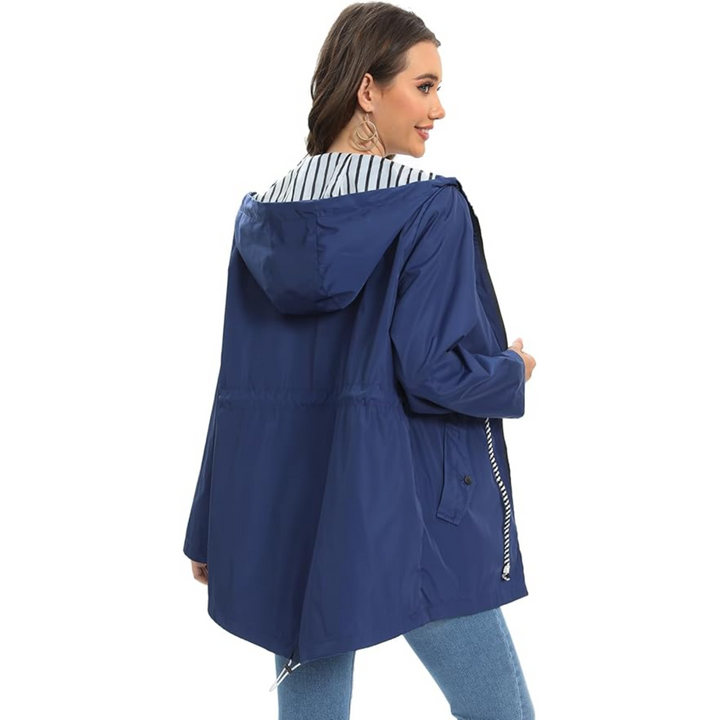 Navy blue waterproof raincoat with a hooded, longline design and a contrast striped lining, worn by a woman.