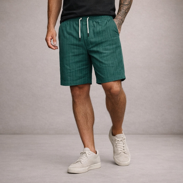 Men wearing dark green textured linen shorts with an adjustable white drawstring waist and a relaxed straight-leg fit.