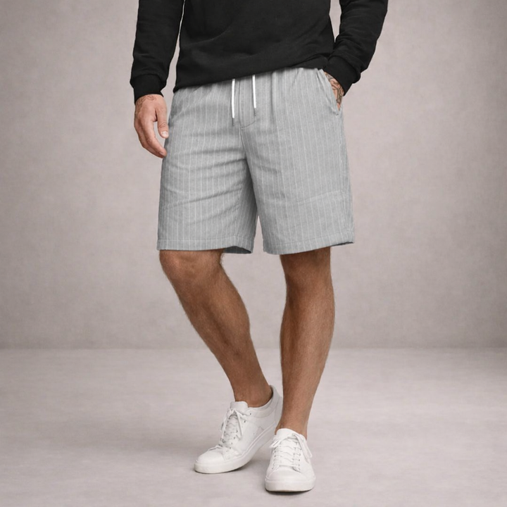 Men's light grey pinstripe linen shorts featuring an elasticated drawstring waist and a relaxed, straight-leg fit.
