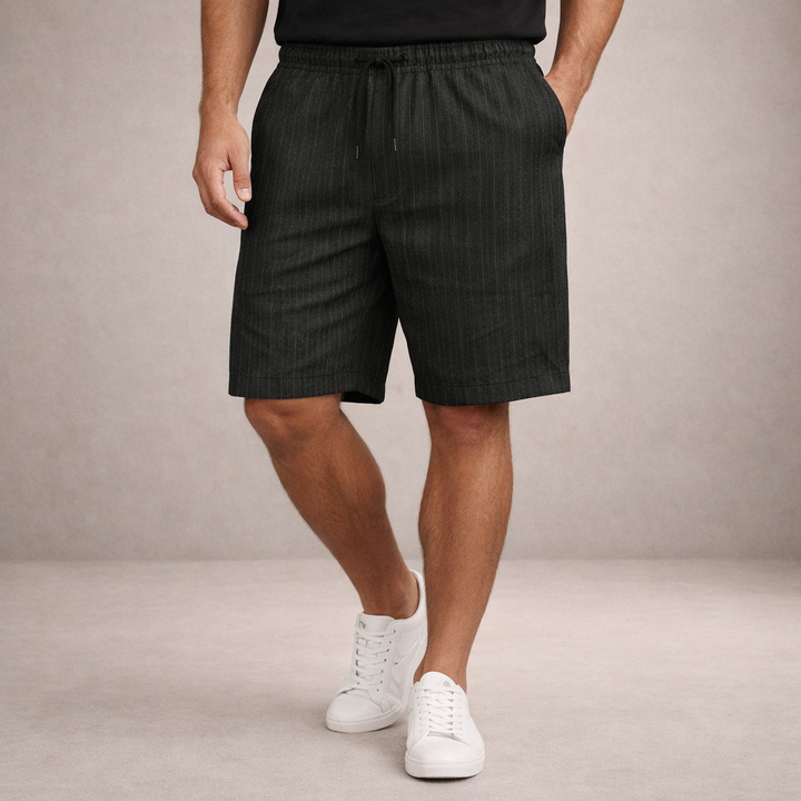 Men wearing charcoal grey pinstripe linen-look drawstring shorts with an elasticated waist and side pockets.
