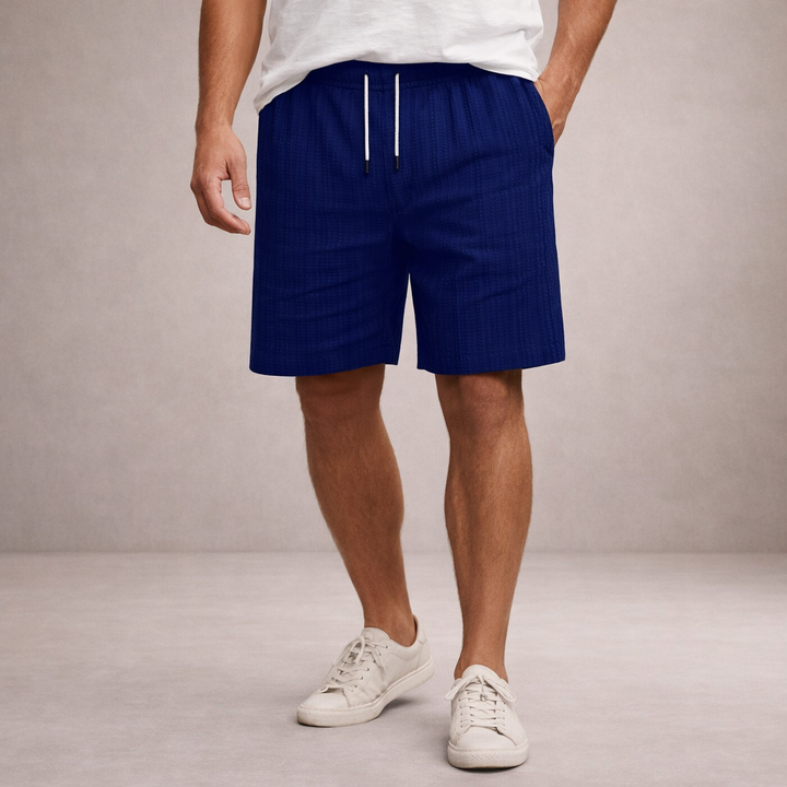 Men wearing navy blue linen-look drawstring shorts with an elasticated waist and side pockets.