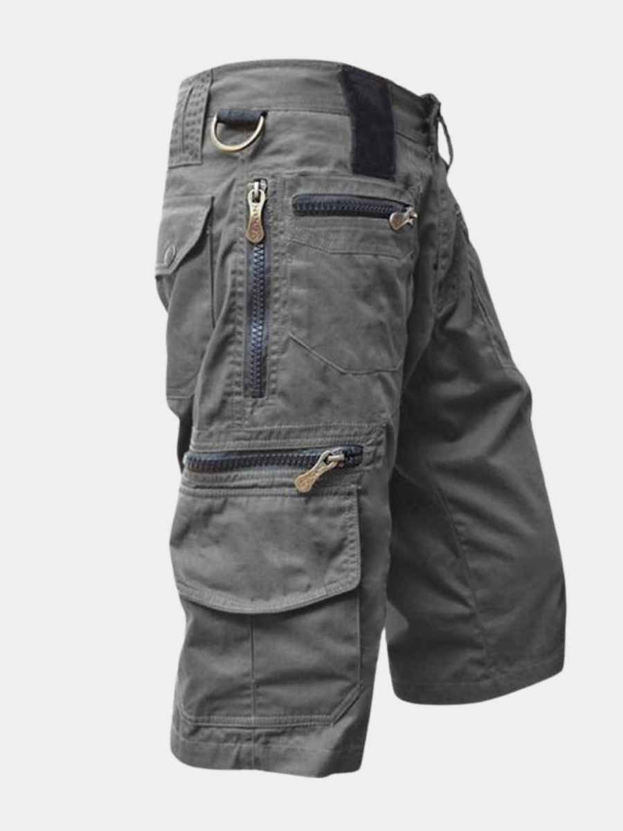 Charcoal grey cotton cargo shorts featuring multiple zip and flap pockets, a D-ring, and a structured, modern fit.