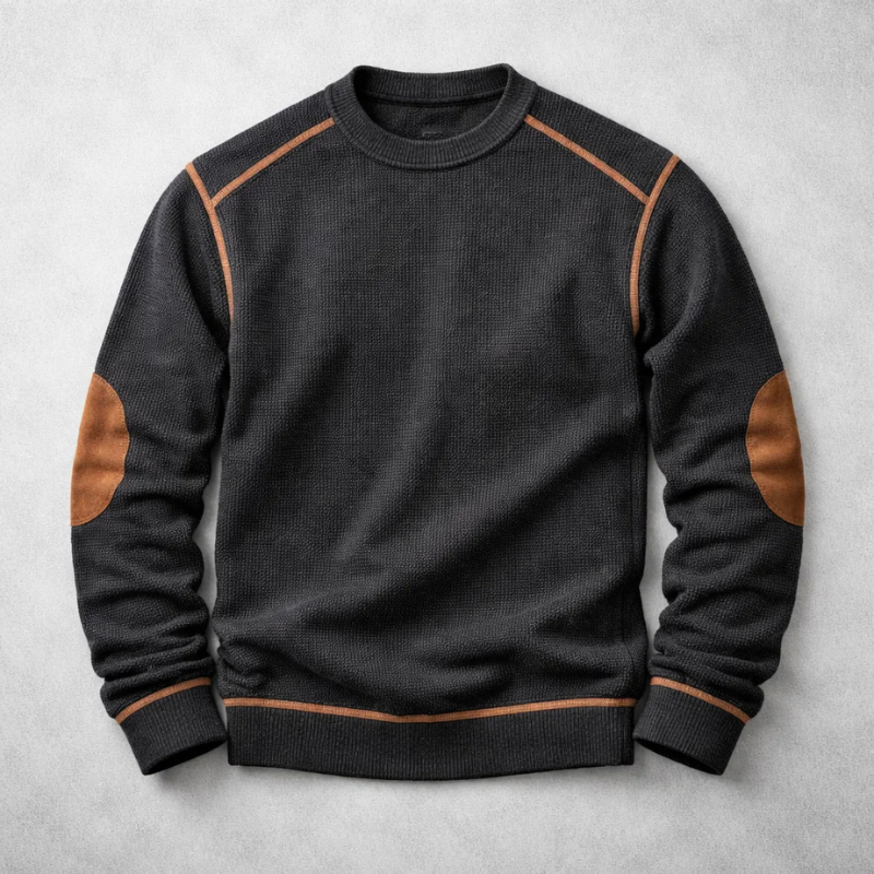 Black waffle-knit crew neck jumper with brown contrast elbow patches and matching trim details on a grey background.