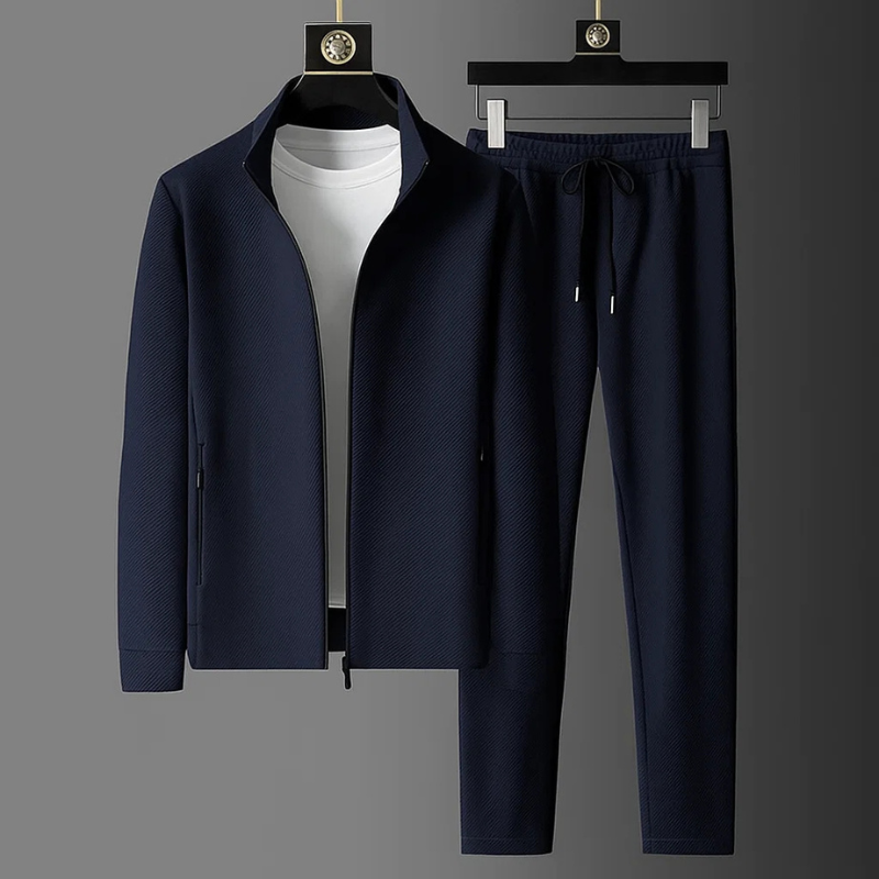 Navy blue textured zip-up tracksuit with funnel collar and matching drawstring trousers on hangers.