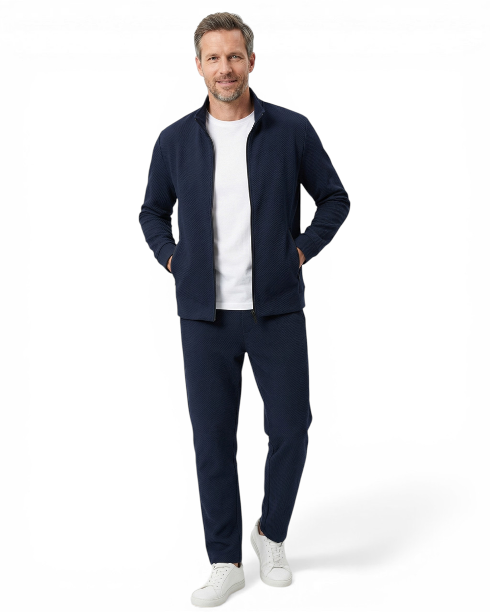 Man wearing a navy blue textured zip-up tracksuit with a funnel neck and matching slim-fit drawstring trousers.