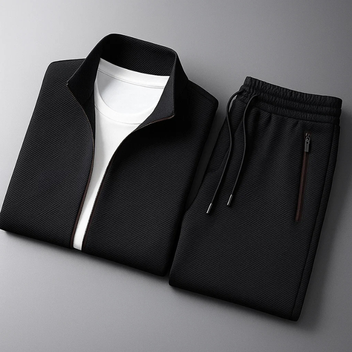 Black textured men's tracksuit set with a funnel-neck zip-up jacket and matching drawstring trousers on a grey background.
