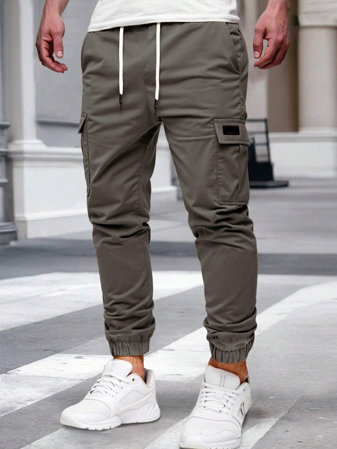 Olive green men's cargo joggers with a drawstring waist, side pockets, and elasticated cuffed hems.