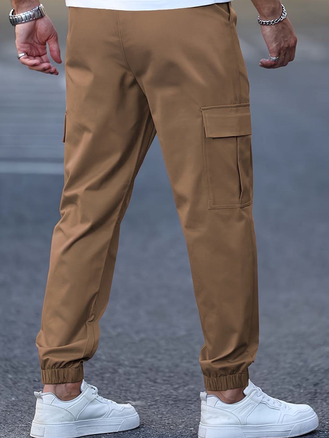Tan men's cargo joggers with side pockets, elasticated cuffs, and a tapered fit worn with white trainers.
