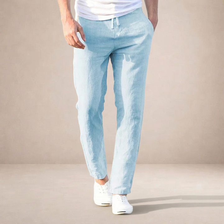 Light blue men's straight-leg linen trousers with a drawstring waist and side pockets, styled with a white t-shirt.