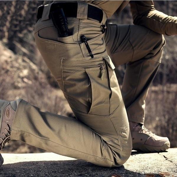 Tan tactical cargo trousers with reinforced stitching, multiple utility pockets, and a durable fit for outdoor hiking.
