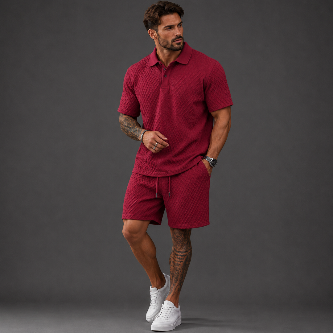 Man wearing a burgundy textured short-sleeve polo shirt and matching drawstring shorts set with white sneakers.