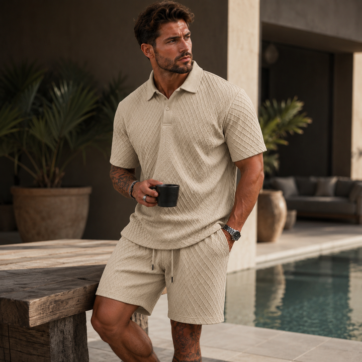 Man wearing a beige textured short-sleeve polo shirt and matching drawstring shorts by a poolside.