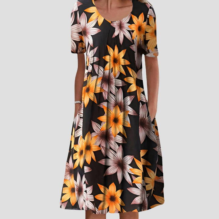 Short sleeve A-line midi dress in black with a vibrant yellow and white floral print, featuring a scoop neck and side pockets.