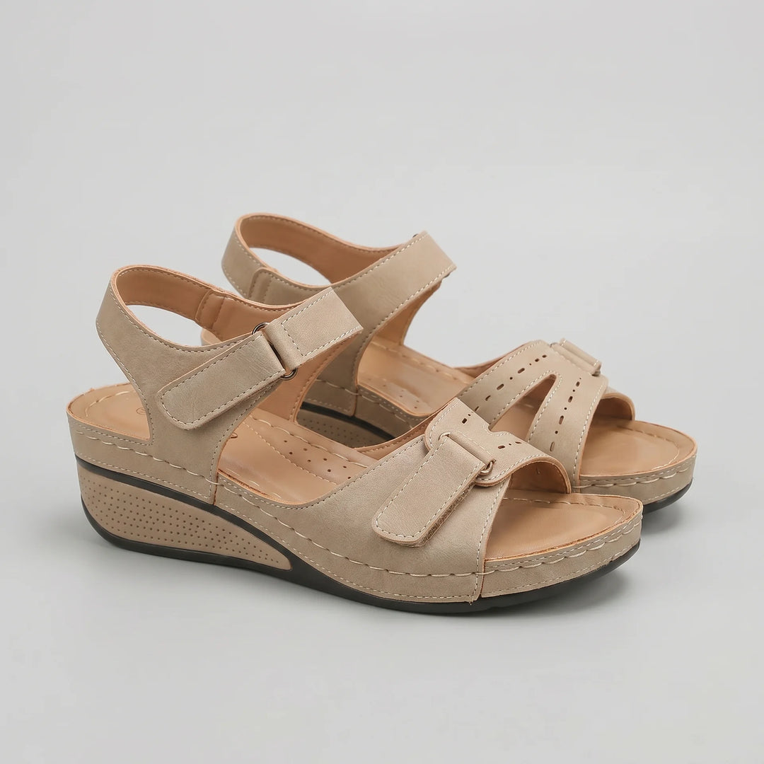 Beige sandals with a wedge sole on a light gray background