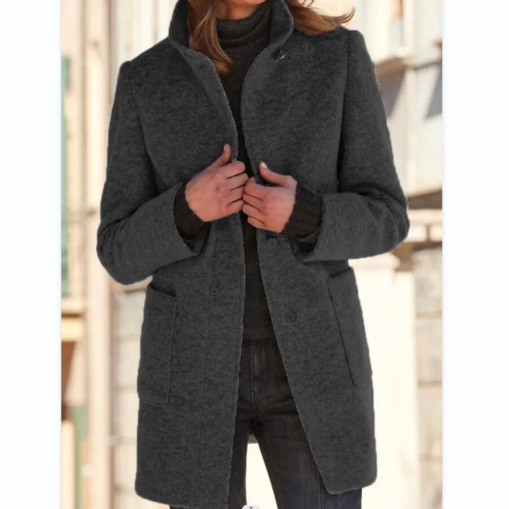 Charcoal grey longline wool-blend coat featuring a standing funnel collar, button-front closure, and practical front pockets.