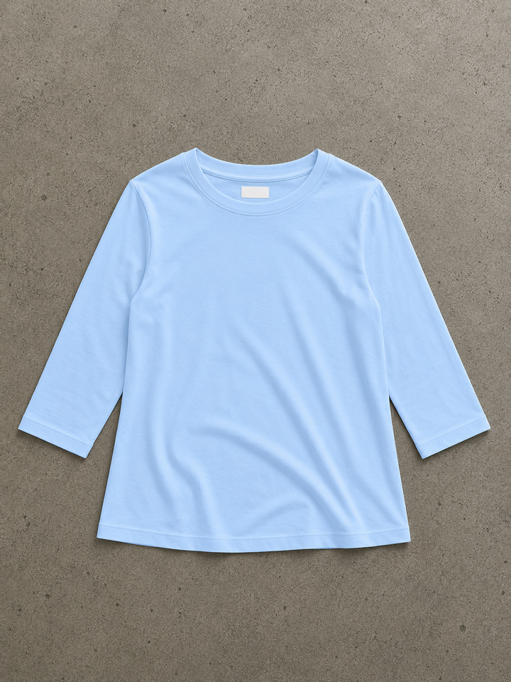 Light blue round-neck top with half sleeves and a relaxed fit, laid flat on a grey textured background.