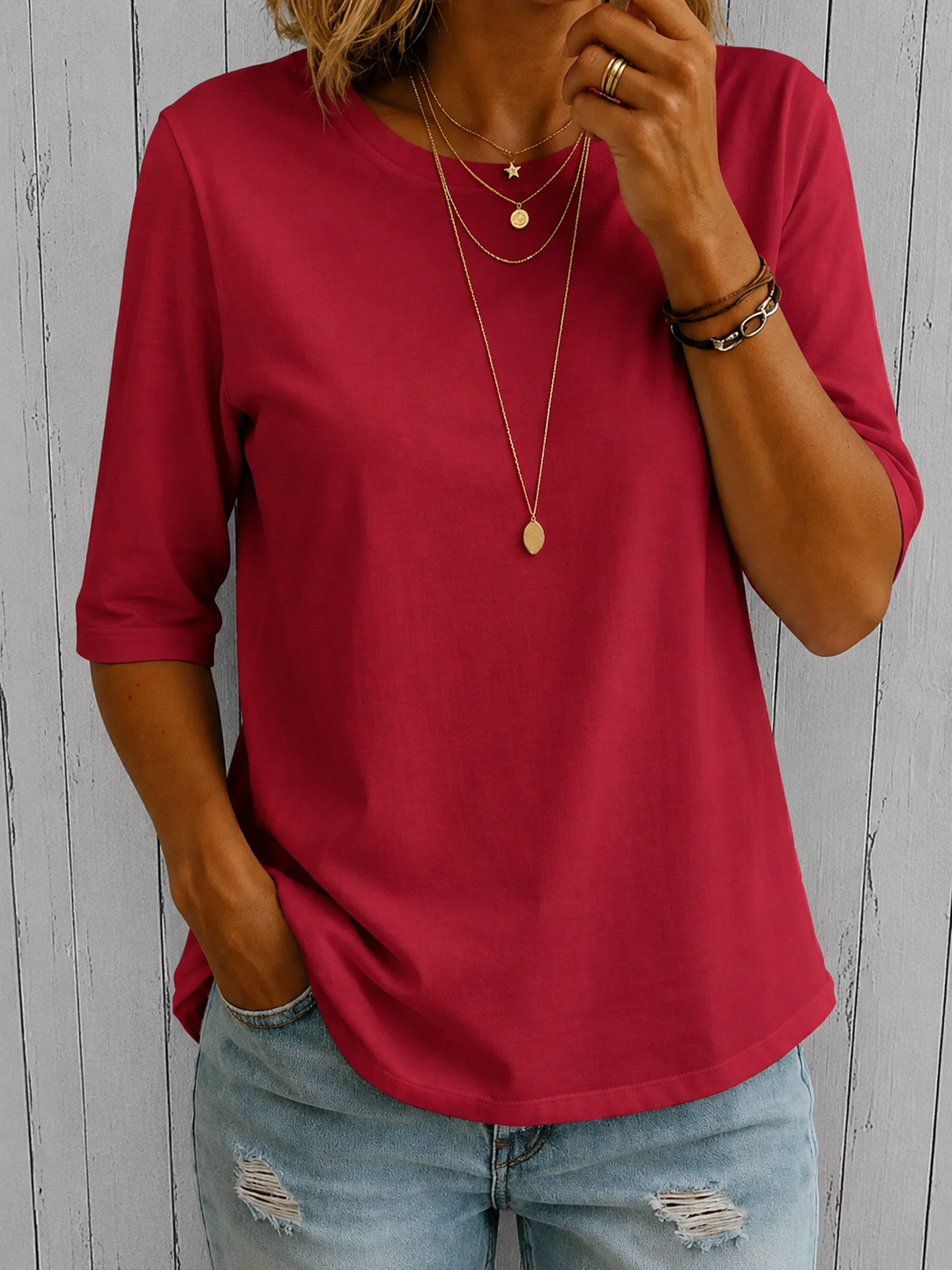 Women's deep pink round-neck top with half sleeves and a relaxed fit, styled with light wash distressed jeans.