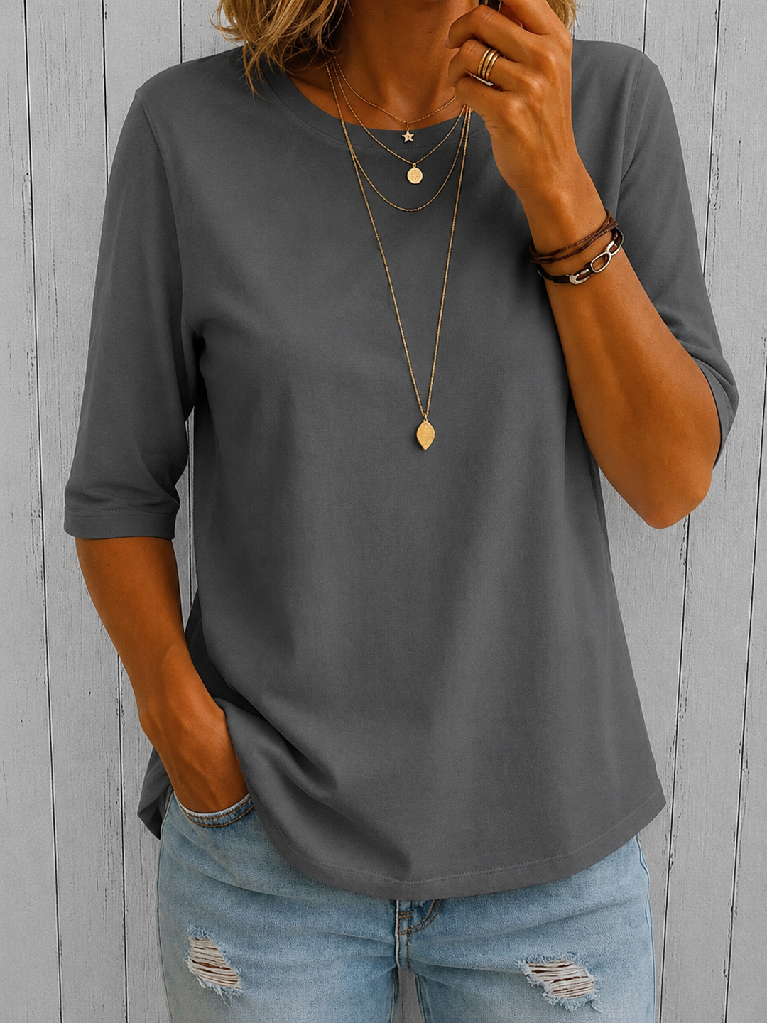Charcoal grey round-neck top with half sleeves and a relaxed fit, styled with light wash distressed jeans.