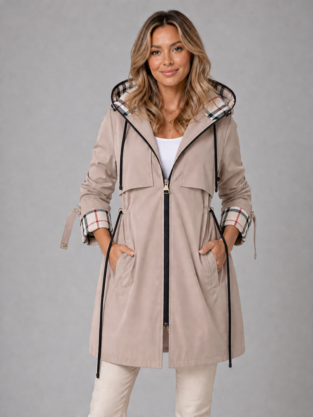 Beige longline hooded coat with a drawstring waist, front zip, and stylish contrast check lining on the hood and cuffs.