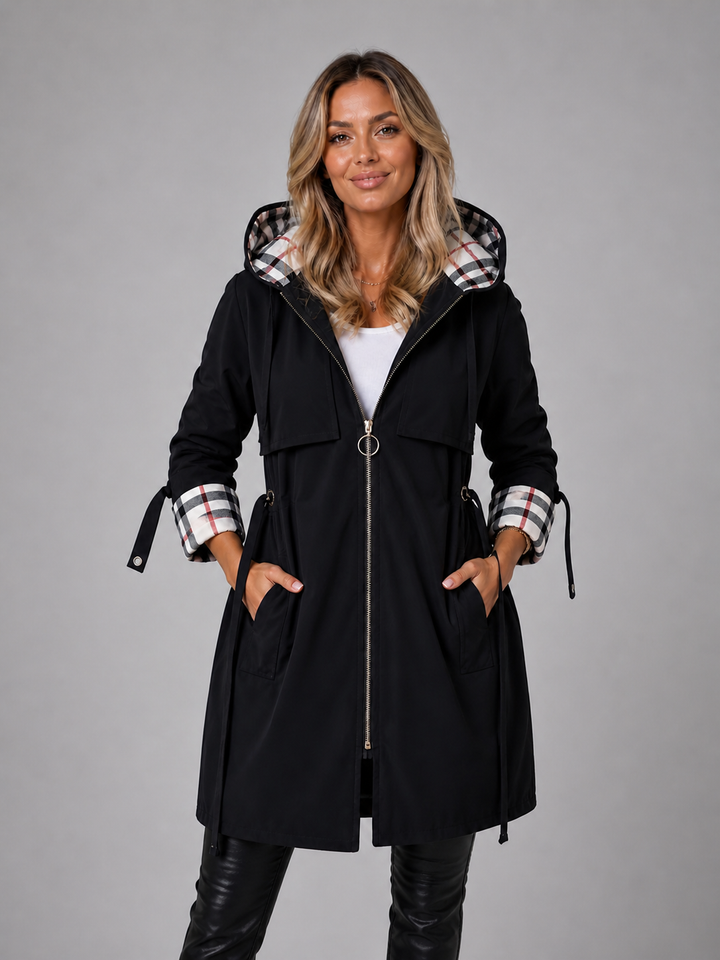 Black longline hooded coat with a drawstring waist, zip front, and stylish check-lined hood and roll-up cuffs.
