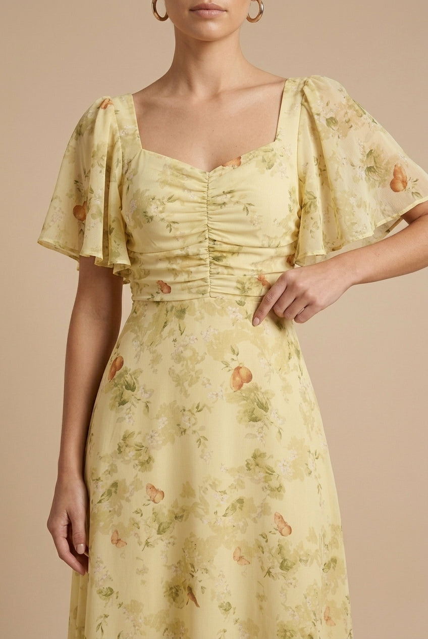 Delilah women's floral square neck maxi dress in soft yellow with ruched bodice and flutter sleeves.