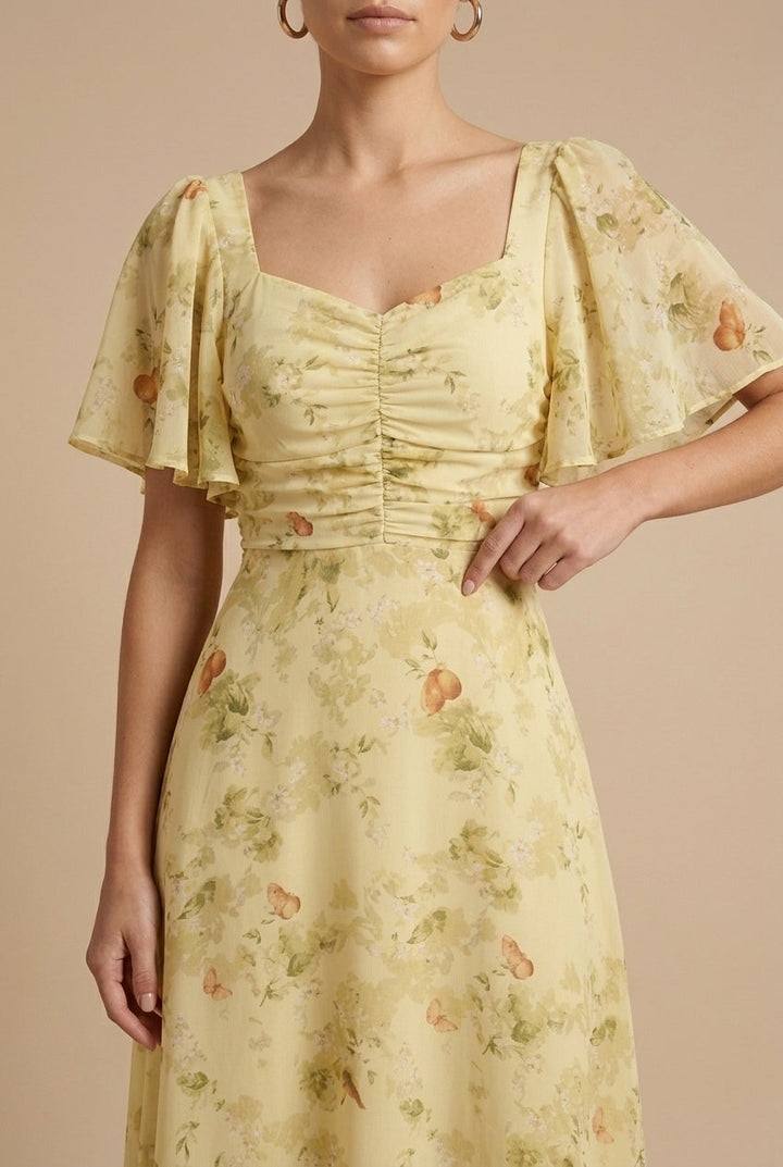 Delilah women's floral square neck maxi dress in soft yellow with ruched bodice and flutter sleeves.