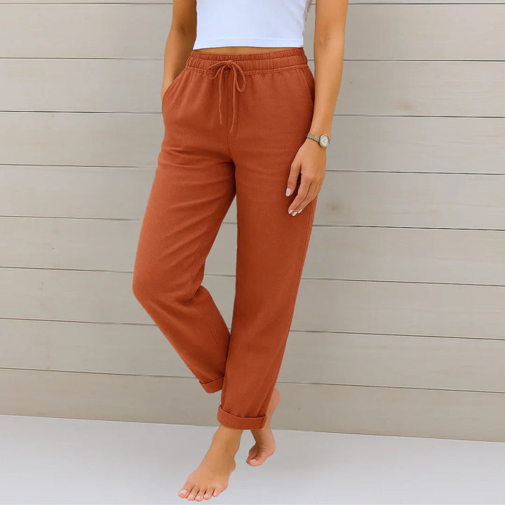 Delilah women's high-waisted relaxed trousers in a rich terracotta, featuring an elastic drawstring waist and cuffed ankles.