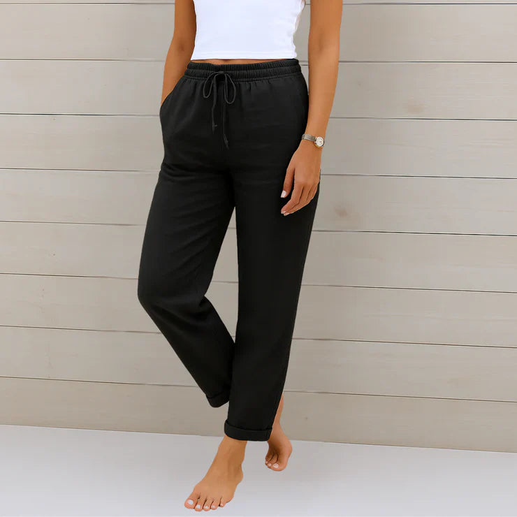 Delilah women's high-waisted relaxed black trousers with an elastic drawstring waist and rolled cuffs.