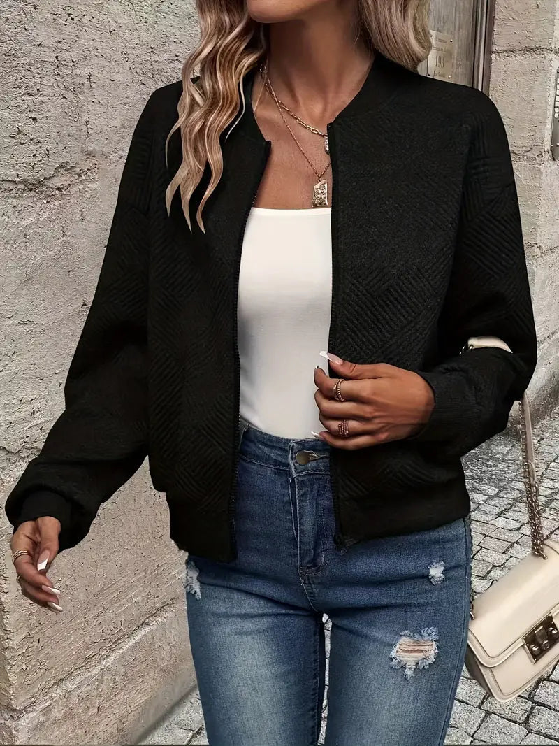 Black textured zip-up cardigan with a ribbed stand collar, worn over a white top and blue distressed jeans.