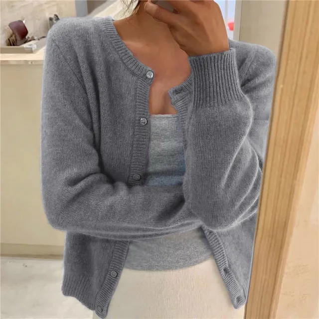 Grey knit crew neck cardigan with long sleeves, ribbed cuffs, and a button-down front worn over a matching grey tank top.