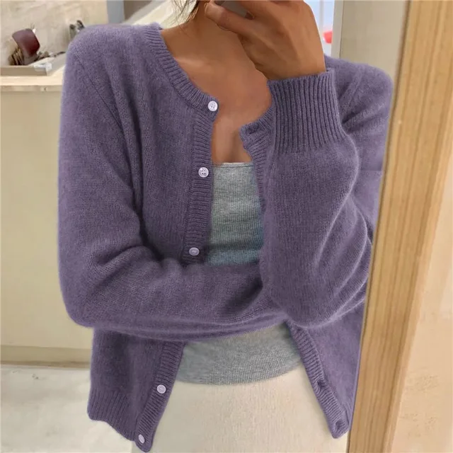 Purple knit crew neck cardigan with long sleeves, ribbed cuffs, and a button-down front worn over a grey tank top.