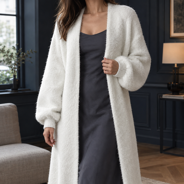 Delphine longline open-front cardigan in a plush, white fluffy knit with ribbed cuffs layered over a dark slip dress.