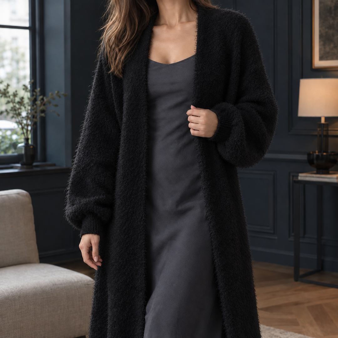 Black longline fluffy knit cardigan with an open front and ribbed cuffs, layered over a matching dark slip dress.