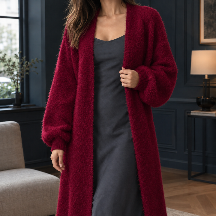 Plush burgundy longline cardigan in a soft, fluffy knit with an open front and ribbed cuffs, layered over a dark slip dress.