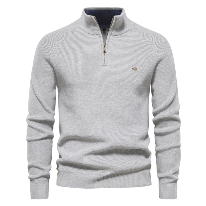Light grey men's quarter-zip knit sweater with ribbed sleeves, a high collar, and a small metallic logo detail.